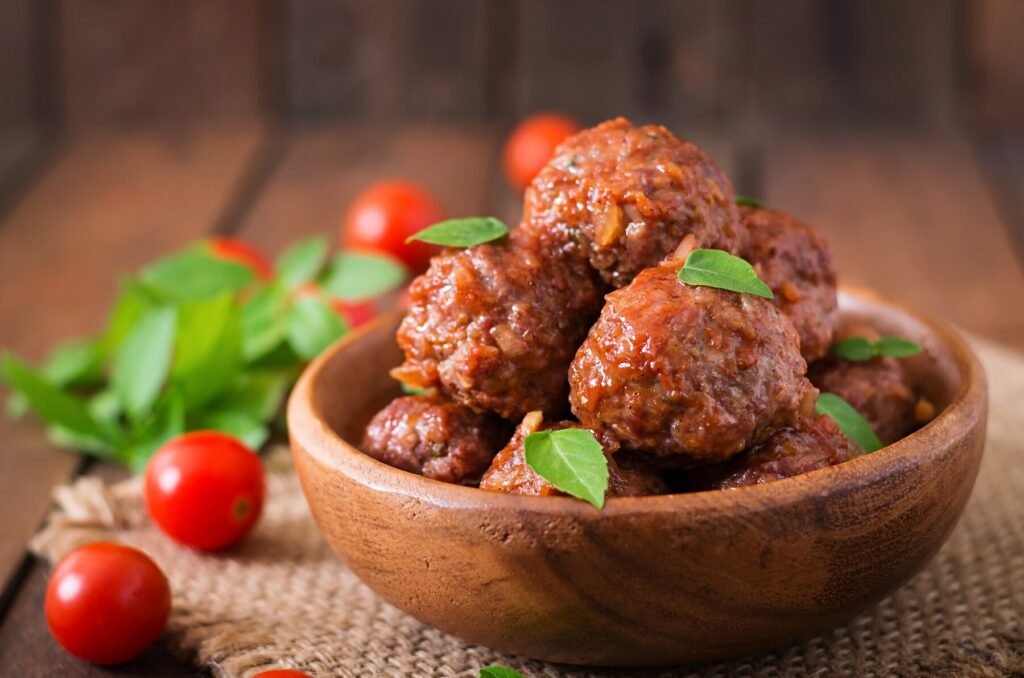 a bowl of meatballs with leaves