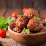 a bowl of meatballs with leaves