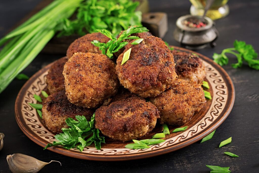 a plate of meatballs and greens