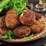 a plate of meatballs and greens